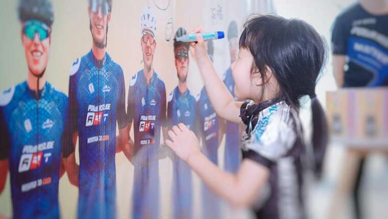 Enfant qui dessine sur un poster de l'équipe Powerslide 2023
