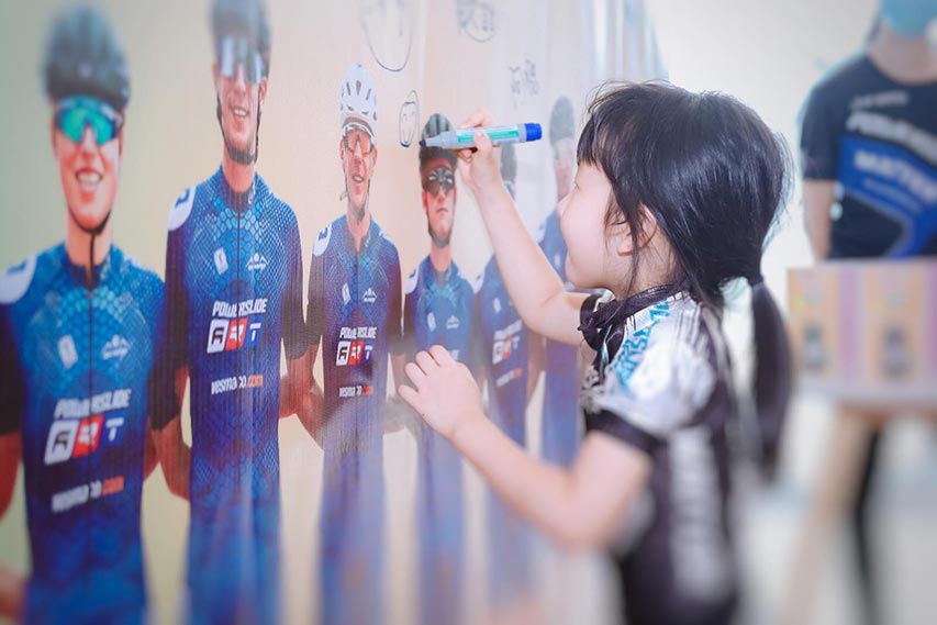 Enfant qui dessine sur un poster de l'équipe Powerslide 2023